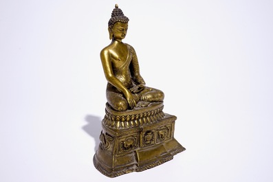 Un mod&egrave;le d'un Bouddha assis sur un trone en bronze dor&eacute;, Nepal ou Tibet, 19/20&egrave;me