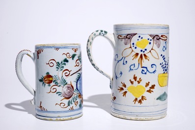 Two polychrome Dutch Delft mugs with birds, vases and flowers, 18th C.