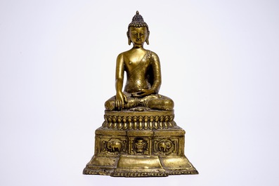 A gilt bronze model of Buddha seated on a throne, Nepal or Tibet, 19/20th C.