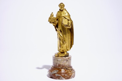 A gilt bronze model of a saint on a later marble base, 17th C.