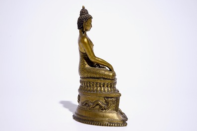 A gilt bronze model of Buddha seated on a throne, Nepal or Tibet, 19/20th C.