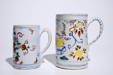 Two polychrome Dutch Delft mugs with birds, vases and flowers, 18th C.