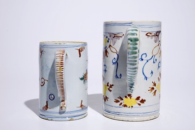 Two polychrome Dutch Delft mugs with birds, vases and flowers, 18th C.