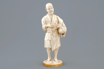 A Japanese ivory okimono of a chicken farmer, Meiji, 19th C., signed