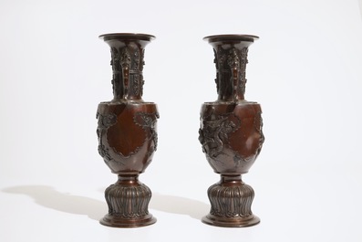A pair of Japanese bronze relief-decorated vases, Meiji, 19th C.