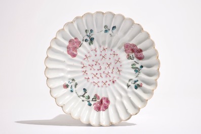 Een Chinese famille rose lotusvormige kop en schotel met reli&euml;fdecor, Yongzheng