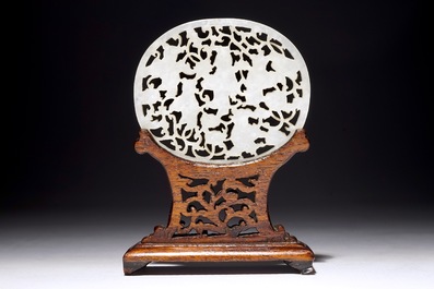 A Chinese reticulated jade plaque, on wooden stand, 19th C.