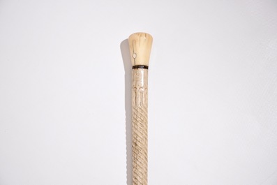 A scrimshaw whalebone cane with a sperm whale tooth handle, 19th C.