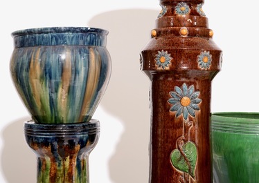 A large collection of Flemish pottery, mostly jardinieres on stands, early 20th C.