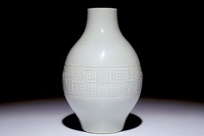 Un vase en forme d'olive en porcelaine de Chine monochrome blanc &agrave; d&eacute;cor en relief, marque Qianlong, 19&egrave;me