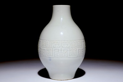 Een Chinese monochrome witte olijfvormige vaas met reli&euml;fdecor, Qianlong merk, 19e eeuw