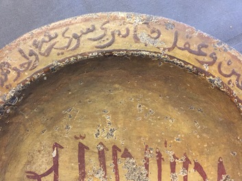 Een islamitische schotel uit steen gehouwen met kleinvuur decor van kalligrafie en een magisch vierkant achterop, 16/17e eeuw