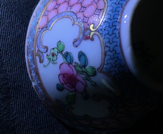 A pair of Chinese famille rose cups and saucers with a cat near a flower basket, Yongzheng