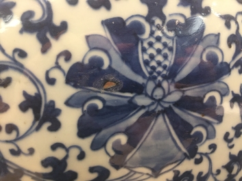 A pair of Chinese blue and white lotus scroll fishbowls, 19th C.