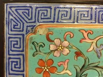 A Chinese famille rose enamel tile plaque mounted in a wood stand, 19th C.