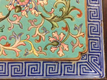 Une plaque en porcelaine de Chine famille rose, mont&eacute; dans un socle en bois, 19&egrave;me
