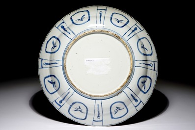 Un plat en porcelaine de Chine bleu et blanc de type Kraak &agrave; d&eacute;cor d'un vase fleuri, Wanli
