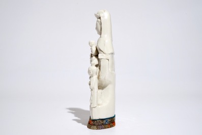 Een Chinees Dehua blanc de Chine model van Guanyin met een kind en acolieten, Kangxi