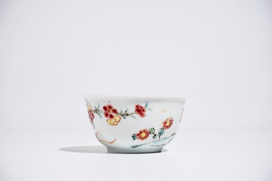 A Chinese famille rose cup and saucer with figures in a garden, Yongzheng
