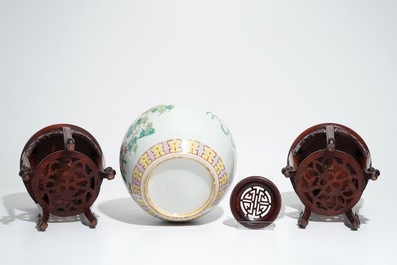 A Chinese famille rose jar and cover, with a pair of wooden stands, 19/20th C.