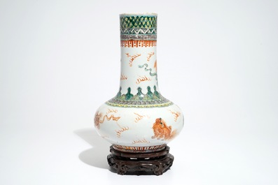 A Chinese famille verte vase with Buddhist lions on wooden stand, 19th C.