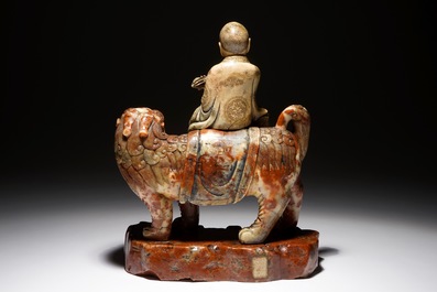 Une figure de l'immortel Vajraputra sur un lion bouddhiste en pierre de savon, Kangxi/Qianlong