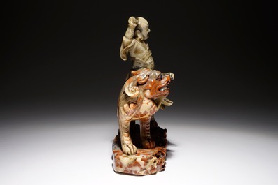 A Chinese soapstone figure of the immortal Vaishravana on a Buddhist lion, Kangxi/Qianlong