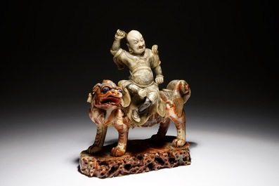 Een Chinese zeepstenen figuur van de onsterfelijke Vaishravana op een boeddhistische leeuw, Kangxi/Qianlong