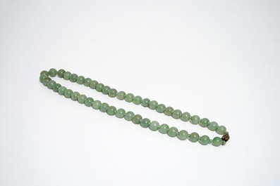 A Chinese green jade beads necklace with silver lock, 19/20th C.