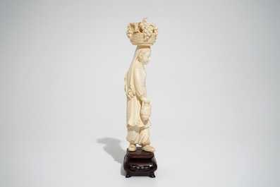 Une figure d'une femme au panier de fruits en ivoire sculpt&eacute;, Chine, 2&egrave;me quart du 20&egrave;me