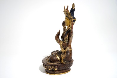 A Sino-Tibetan gilt bronze figure of Manjusri with coral and turquoise insets, 19/20th C.