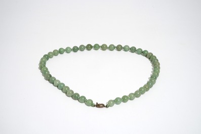 A Chinese green jade beads necklace with silver lock, 19/20th C.