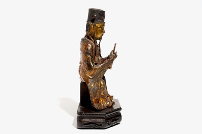 A Chinese partly gilt and polychrome bronze figure of Wenchang Dijun on wooden stand, Ming