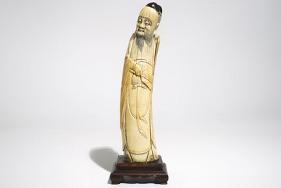 A Chinese ivory figure of the immortal Han Zhongli, on wooden base, late Ming
