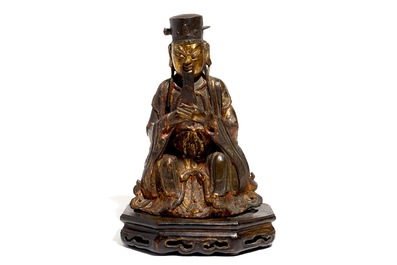 A Chinese partly gilt and polychrome bronze figure of Wenchang Dijun on wooden stand, Ming