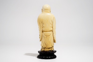 Een Chinese ivoren figuur van Boeddha met waaier, op lotusvormige sokkel, 19e eeuw