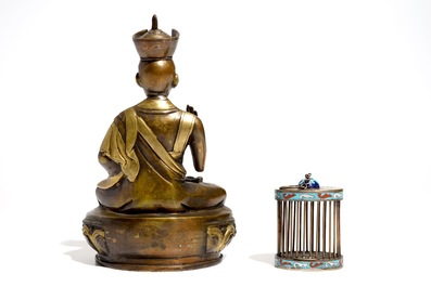 A Chinese bronze model of a seated Buddha and a cloisonn&eacute; cricket case, 19/20th C.