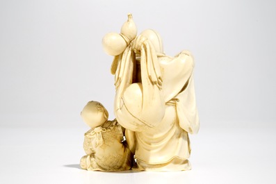 A Chinese ivory group of Buddha with a boy, signed, late 19th C.