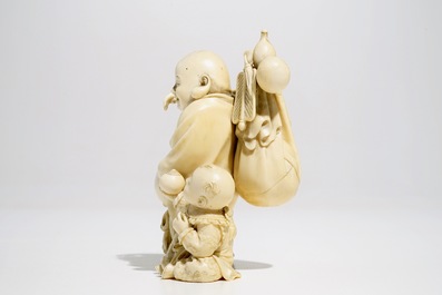 A Chinese ivory group of Buddha with a boy, signed, late 19th C.