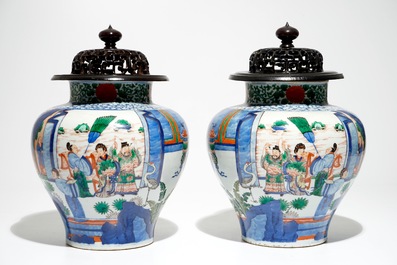 A pair of Chinese wucai baluster vases with carved lids and bases, 19th C.