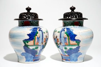 A pair of Chinese wucai baluster vases with carved lids and bases, 19th C.