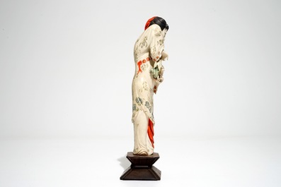A Chinese polychrome ivory figure on wooden stand, 2nd quarter 20th C.