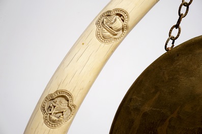 Un gong chinois en laiton orn&eacute; de deux d&eacute;fenses en ivoire sculpt&eacute;, 19/20&egrave;me