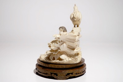 Un groupe d'une fille et un coq en ivoire sculpt&eacute; sur socle en bois, 2&egrave;me quart du 20&egrave;me