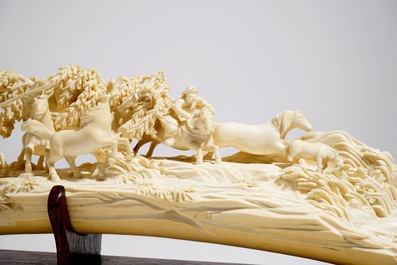 Een Chinese ivoren sculptuur met jachtsc&egrave;ne op houten sokkel, ca. 1900
