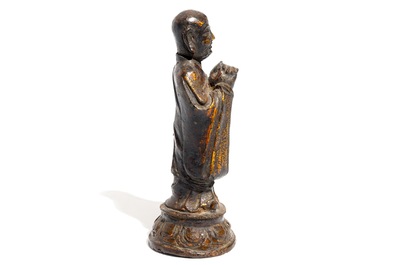 Een Chinese vergulde en gelakte bronzen figuur van een monnik, Ming