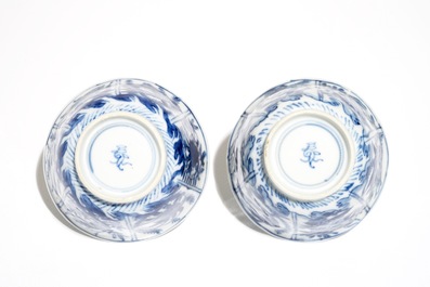 A pair of Chinese bleu and white cups and saucers with crabs and fish, Kangxi