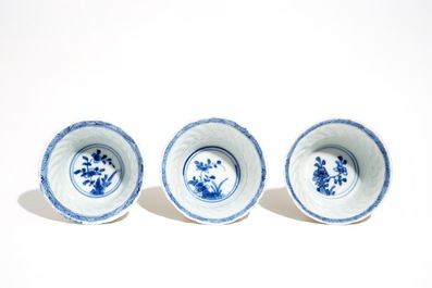 Three Chinese blue and white and caf&eacute; au lait-glazed cups and saucers, Kangxi