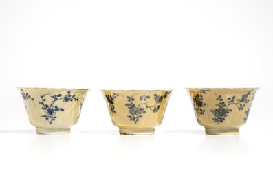 Three Chinese blue and white and caf&eacute; au lait-glazed cups and saucers, Kangxi