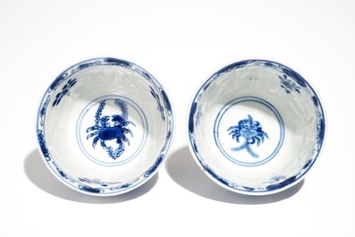 A pair of Chinese bleu and white cups and saucers with crabs and fish, Kangxi